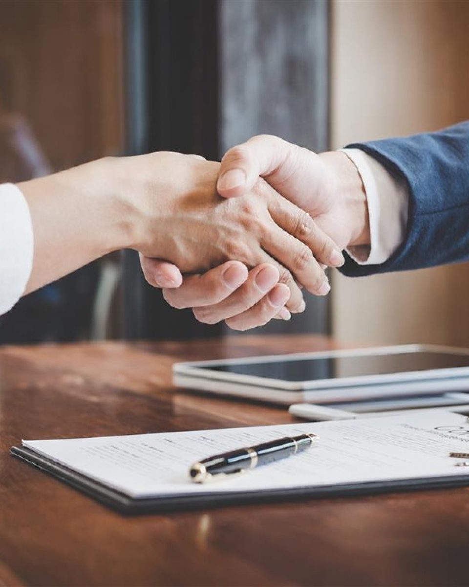 Real estate agent and customers shaking hands together celebrating finished contract after about home insurance and investment loan, handshake and successful deal.